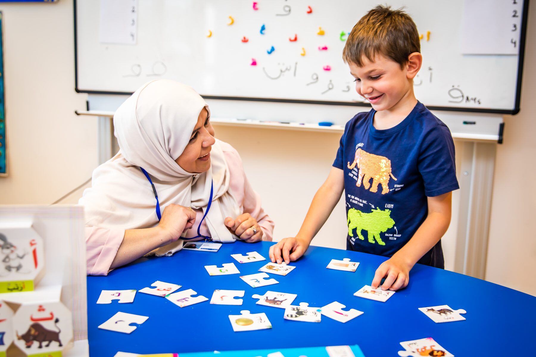 A teacher guides a student in the joyful journey of learning through interactive games. 