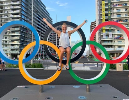 Alumna Saskia in front of the Olympics logo in Tokyo