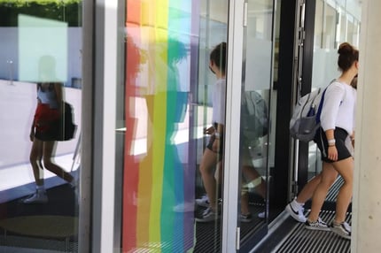 ISL student walking in front of a LGBTQ flag during Pride Month